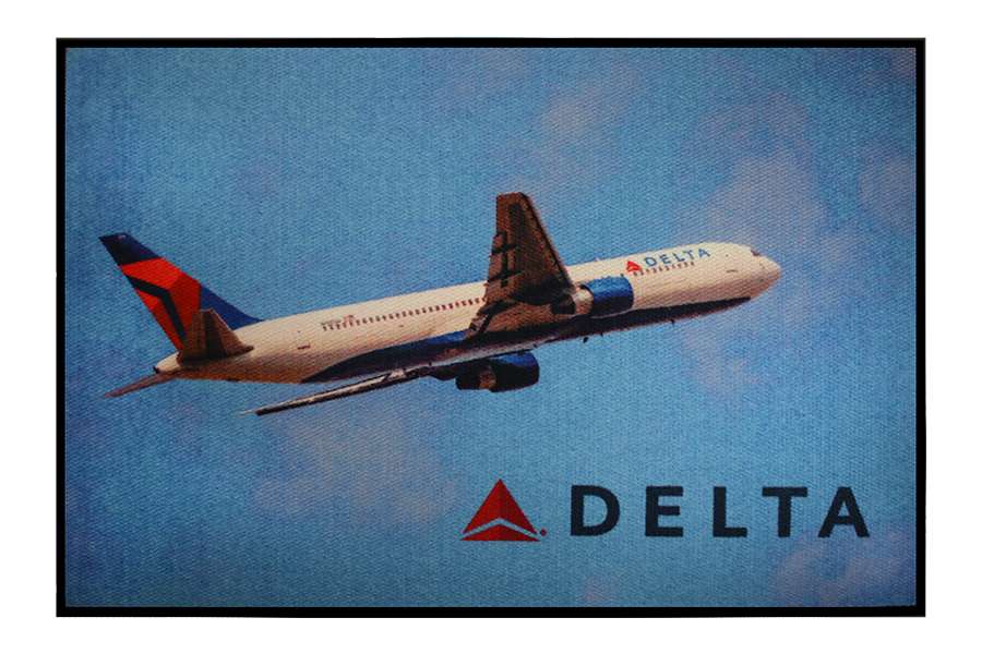 Delta airplane in flight against blue sky.